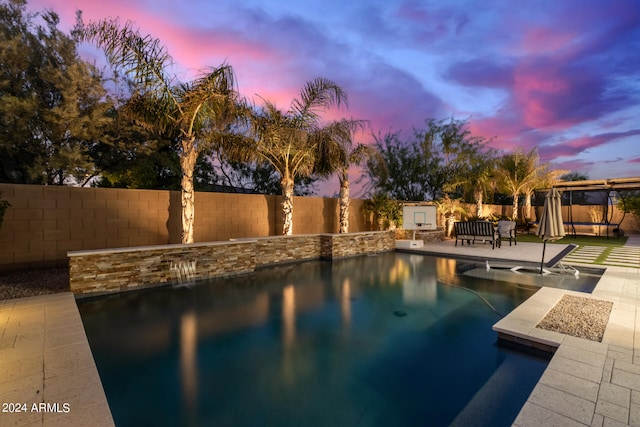 pool at dusk with a patio