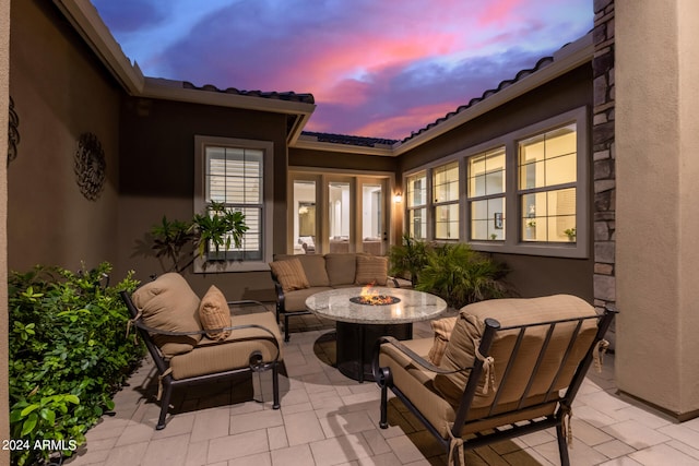 patio terrace at dusk featuring an outdoor living space with a fire pit