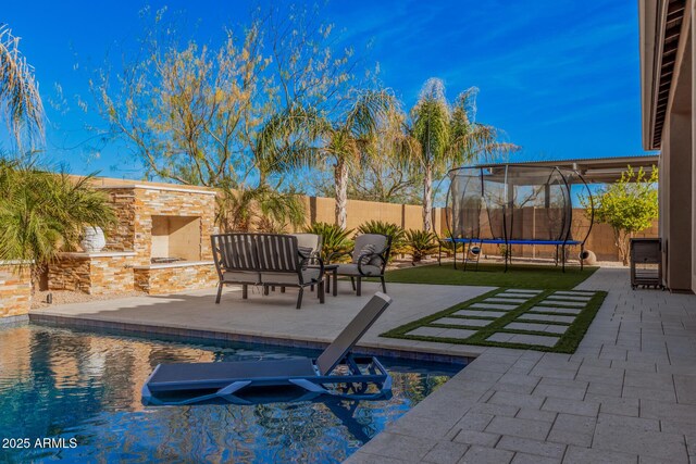 view of swimming pool featuring an outdoor stone fireplace and a patio area