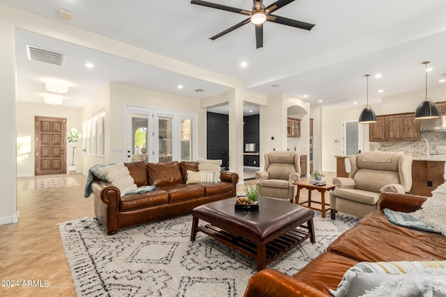 tiled living room with ceiling fan, french doors, and sink