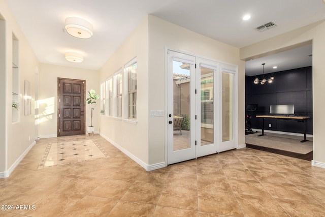 doorway to outside featuring a notable chandelier