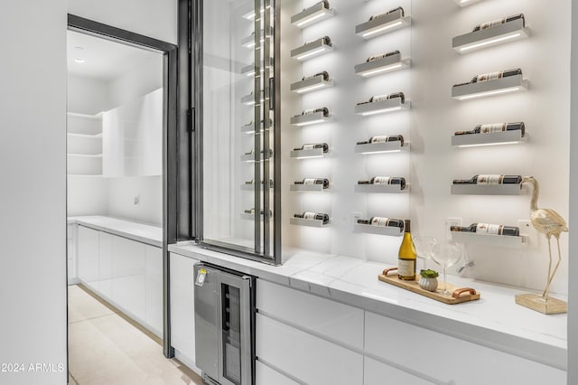 wine area with light tile patterned floors and wine cooler