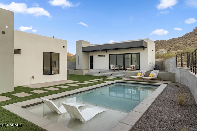 rear view of house featuring an outdoor living space, a patio area, a fenced in pool, and a mountain view