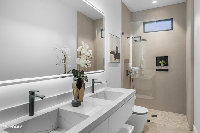 bathroom featuring tile patterned flooring, vanity, tiled shower, and toilet