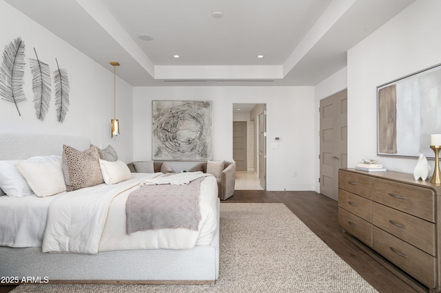 bedroom featuring dark hardwood / wood-style flooring and a tray ceiling