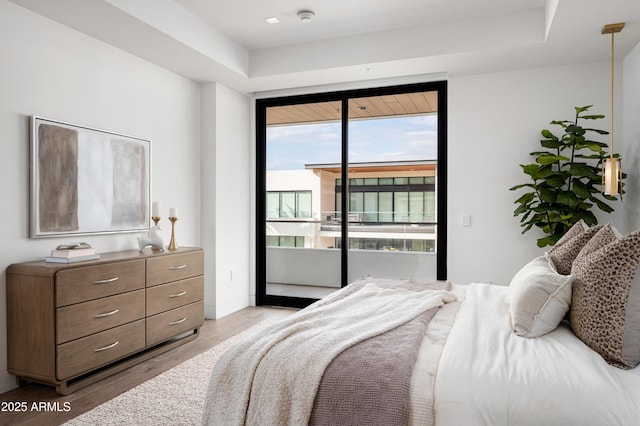 bedroom with access to exterior and light hardwood / wood-style floors