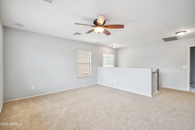 carpeted empty room with a ceiling fan and baseboards
