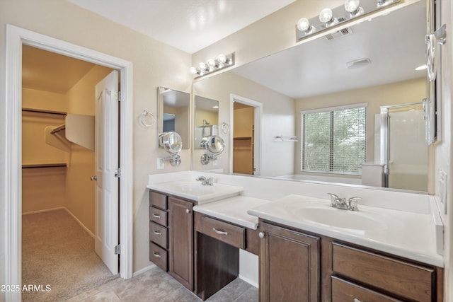 bathroom featuring vanity, a shower with shower door, and a walk in closet