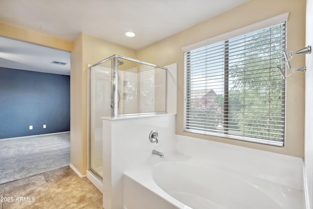 full bathroom featuring healthy amount of natural light, a stall shower, and a garden tub