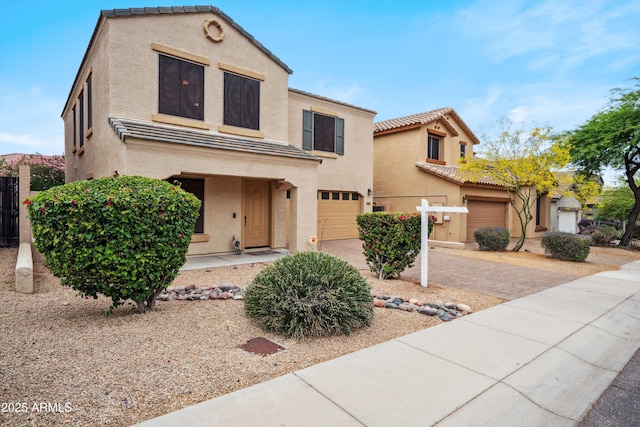 mediterranean / spanish-style house with stucco siding, an attached garage, concrete driveway, and a tiled roof