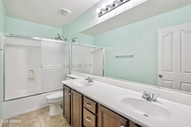 full bath featuring toilet, double vanity, tile patterned floors, and shower / bath combination with glass door