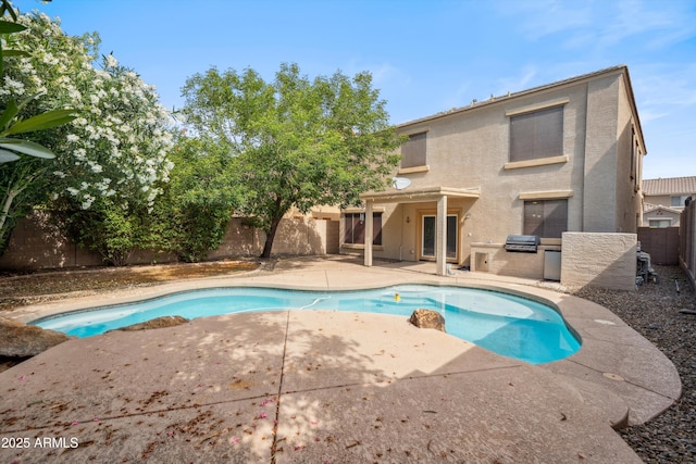 view of swimming pool featuring exterior kitchen, a patio area, a fenced backyard, and area for grilling