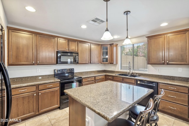 kitchen with black appliances, a sink, a breakfast bar, light tile patterned floors, and recessed lighting
