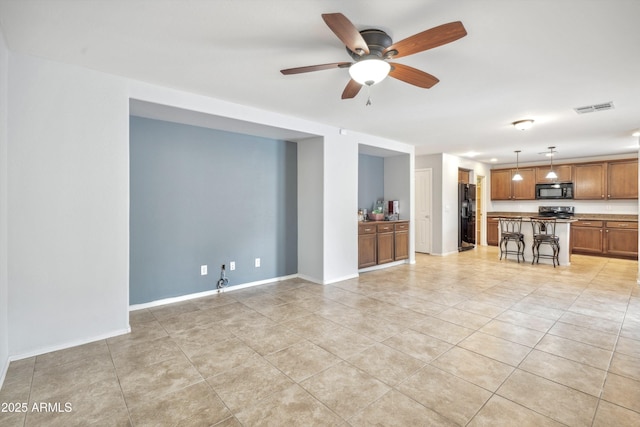 unfurnished living room with light tile patterned floors, a ceiling fan, and baseboards
