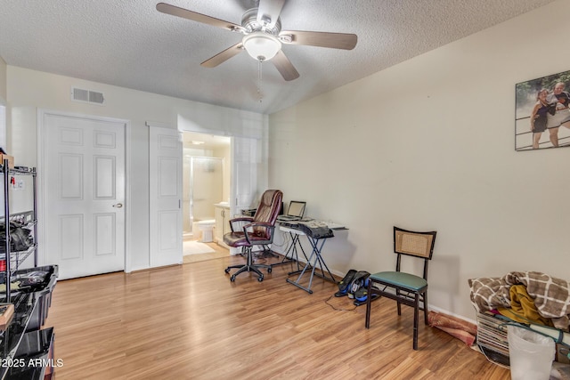 interior space featuring visible vents, a textured ceiling, light wood-style flooring, and ceiling fan