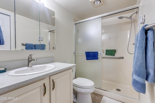 bathroom featuring vanity, tile patterned floors, a shower stall, and toilet