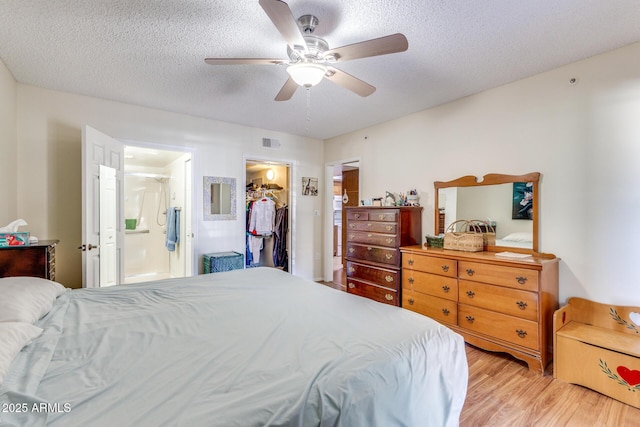bedroom featuring visible vents, a closet, connected bathroom, light wood-style floors, and a spacious closet