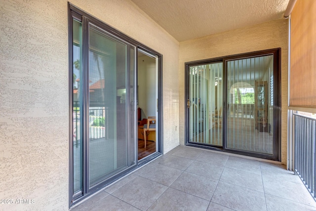 view of exterior entry featuring stucco siding and a balcony
