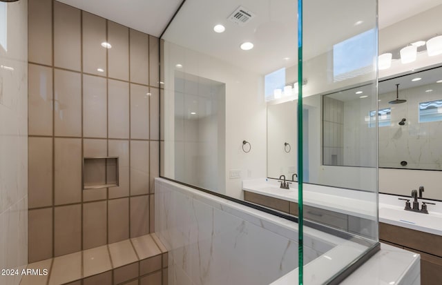 bathroom featuring a tile shower, vanity, and tile walls