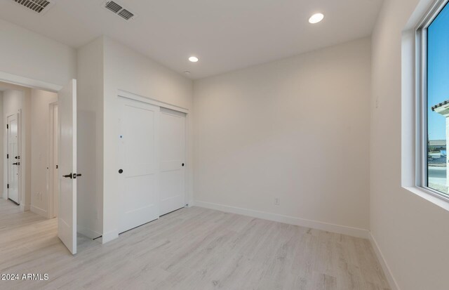 unfurnished bedroom featuring light hardwood / wood-style flooring and a closet