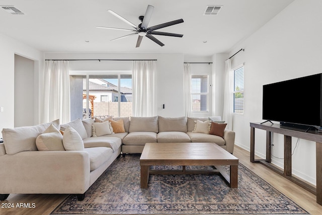 living room with ceiling fan, a wealth of natural light, and wood-type flooring