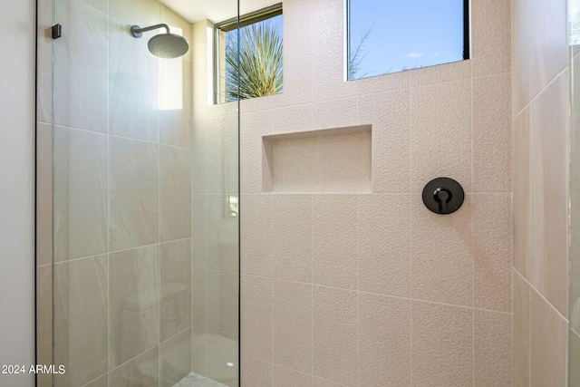 bathroom featuring a tile shower and plenty of natural light