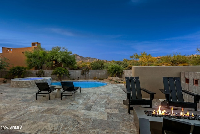 view of swimming pool with a patio, a mountain view, and a fire pit