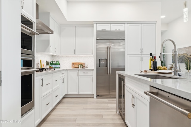 5250 E Deer Valley Dr Unit 140, Phoenix, AZ 85054 - kitchen featuring stainless steel appliances, wall chimney exhaust hood, white cabinetry, light countertops, and recessed lighting