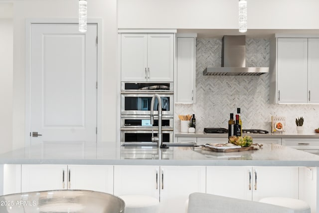 5250 E Deer Valley Dr Unit 140, Phoenix, AZ 85054 - kitchen featuring wall chimney exhaust hood, tasteful backsplash, light countertops, white cabinets, and appliances with stainless steel finishes
