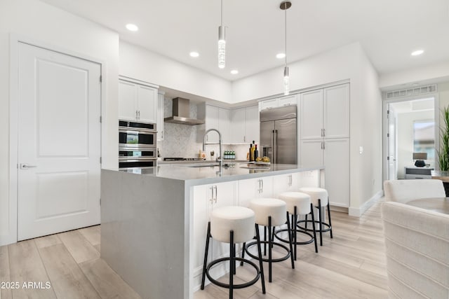 5250 E Deer Valley Dr Unit 140, Phoenix, AZ 85054 - kitchen featuring stainless steel appliances, wall chimney exhaust hood, light wood-style flooring, decorative backsplash, and recessed lighting