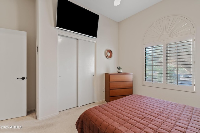carpeted bedroom featuring a closet and baseboards