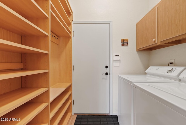 washroom with cabinet space and washing machine and clothes dryer
