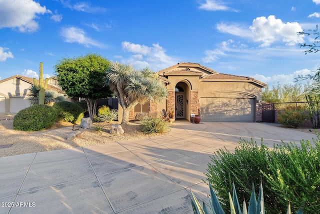 mediterranean / spanish-style home with a tiled roof, driveway, fence, an attached garage, and stucco siding