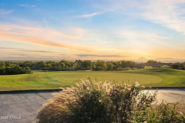 view of property's community with a mountain view, golf course view, and a yard