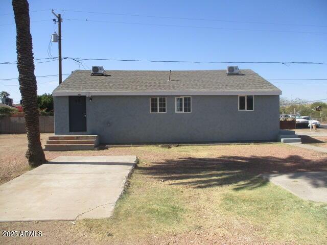 exterior space with entry steps, roof with shingles, and stucco siding