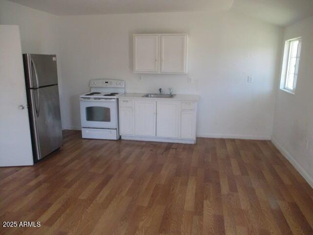 kitchen featuring white cabinets, electric stove, freestanding refrigerator, light wood-type flooring, and a sink