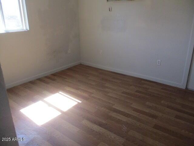 unfurnished room featuring wood finished floors and baseboards