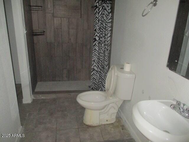 full bath with toilet, tile patterned flooring, a shower stall, and a sink