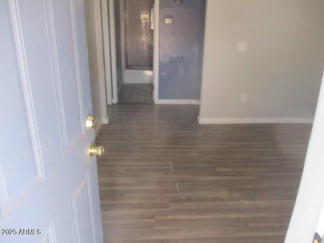 unfurnished room with baseboards and wood finished floors