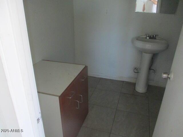 bathroom with baseboards and tile patterned floors