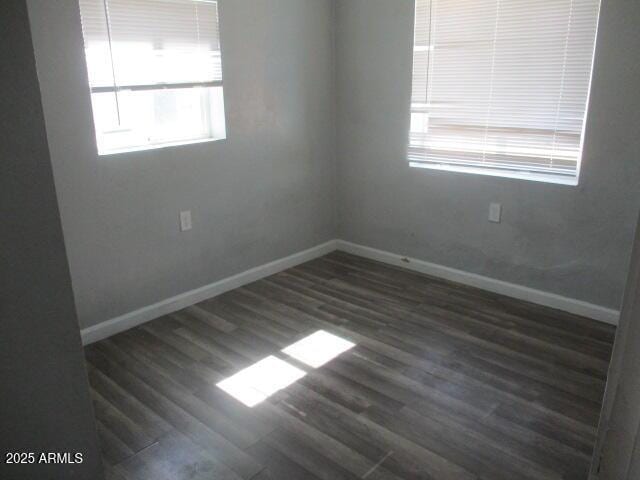 empty room featuring baseboards and wood finished floors