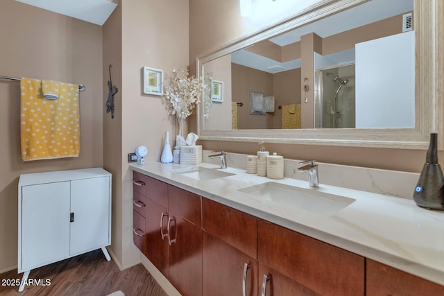 bathroom featuring a shower with shower door, hardwood / wood-style floors, and vanity