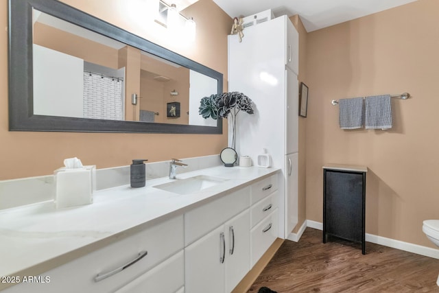 bathroom featuring toilet, vanity, and hardwood / wood-style flooring