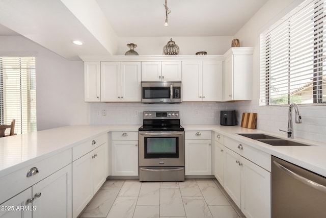 2315 N 52nd St Unit 144, Phoenix, AZ 85008 - kitchen with appliances with stainless steel finishes, a sink, light marble finish floors, white cabinetry, and light countertops