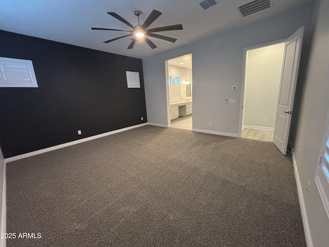 spare room featuring ceiling fan, carpet, visible vents, and baseboards