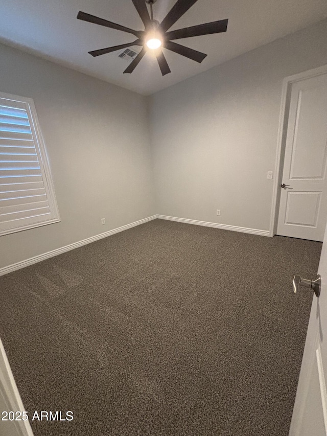 carpeted empty room with baseboards, visible vents, and a ceiling fan