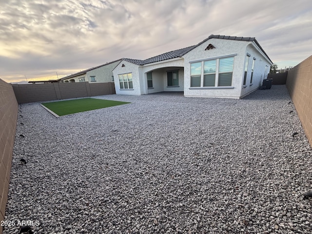 back of house with a tile roof, central air condition unit, stucco siding, a patio area, and a fenced backyard