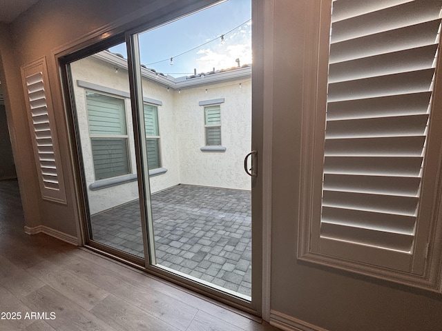 doorway featuring a textured wall and wood finished floors