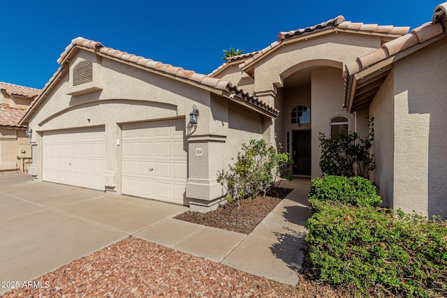 view of front of property with a garage, driveway, and stucco siding