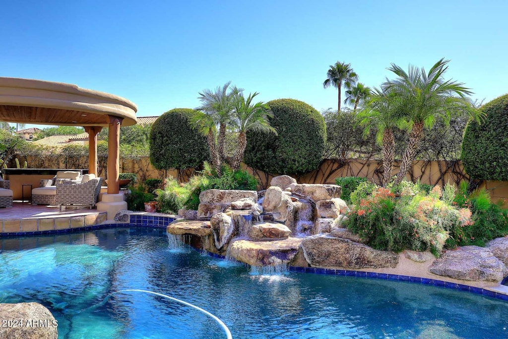 view of pool featuring a gazebo and pool water feature